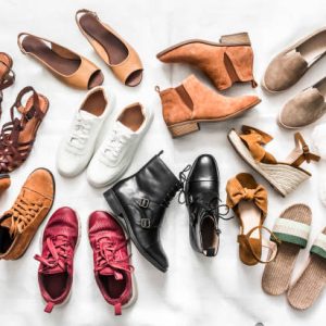 Variety of women's fashion comfortable shoes of all seasons on a light background, top view